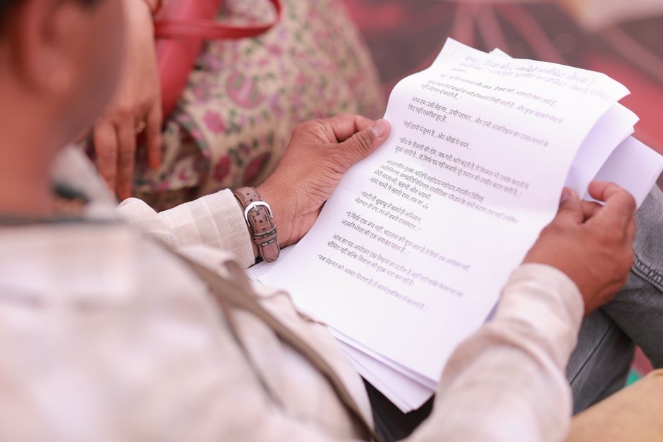 A caretaker reading a printed local ordinance document about community cats
