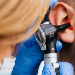 A veterinarian examining a cat's ear for signs of ear mites