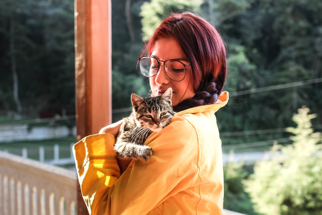 An owner holding their cat while considering rehoming options in Fresno