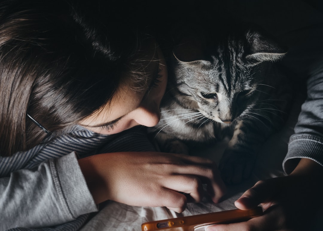 A child gently interacting with a cat as part of family rescue volunteering